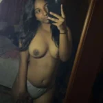 admiring herself with her topless body showing